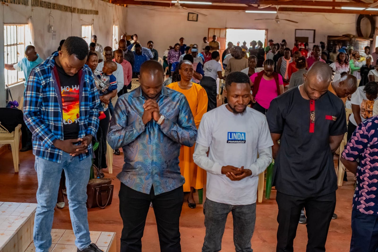 Oburenyi Harrison in prayer with the congregation